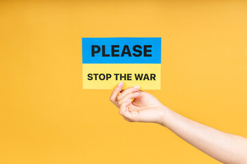 Stop war in Ukraine! Close up photo of ukrainian woman's holding in hands Ukrainian flag isolated...