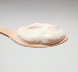 mayonnaise in wooden spoon on white background
