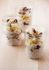 yogurt date and apple parfaits in mason jars on a simple light wood background