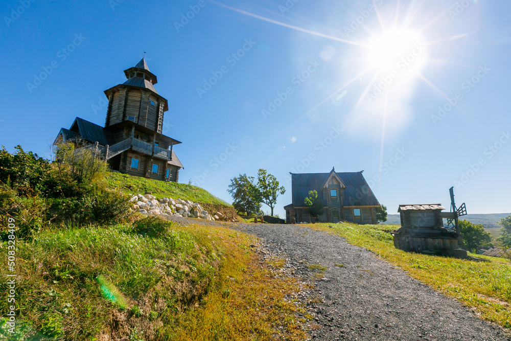 Wall mural Old Slavic tower of the Sun in the old village. Wooden religious pagan tower for prayers. Russian village.