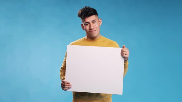 Man looking at camera and smiles while holding blank white sign over an isolated background.