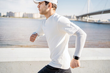 Runner young Man running outside active training, smart sports watch on hand