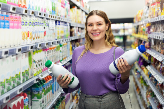 Portrait of young woman customer buying milk and dairy products in grocery