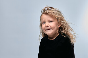 portrait petite fille blonde joyeuse les cheveux au vent