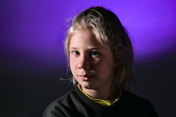 portrait jeune fille blonde sur fond bleu en studio