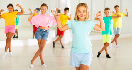 Fototapeta premium Children exercising dance moves together during their group classes.