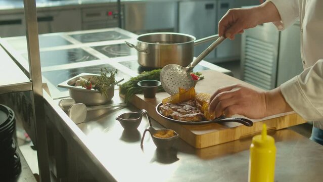 Close-up of Professional Cook Stylishly Serving Steamed Frie and Stake on a Plate.