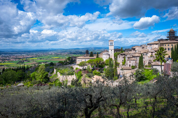 Wide panorama of the ancient houses and countryside surrounding the city of Assisi (Umbria Region, central Italy). Is world famous as birthplace of St. Francis, Italy's christian Patron. - obrazy, fototapety, plakaty