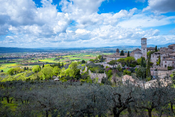Wide panorama of the ancient houses and countryside surrounding the city of Assisi (Umbria Region, central Italy). Is world famous as birthplace of St. Francis, Italy's christian Patron. - obrazy, fototapety, plakaty