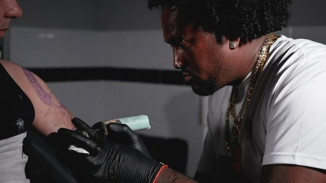 Cinematic slow motion shot of a Tattoo artist creating Body art at the tattoo studio. High quality Full HD footage
