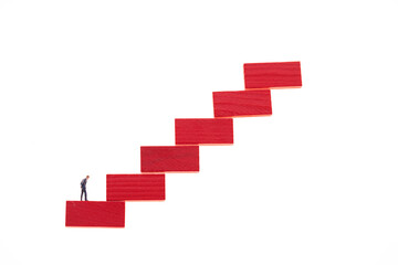 Career ladder concept.Career growth concept. Figurine of a businessman on a red ladder isolated on a white background
