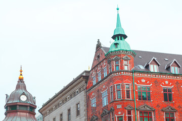 Fototapeta na wymiar Danish architecture with spire . Red bricks building in Scandinavia 