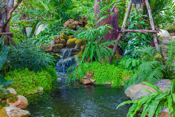 A small garden and a waterfall. Arrangement of gardens outside the building.