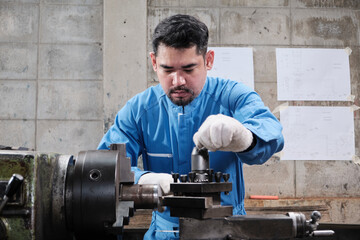 One professional Asian male industry engineer worker works in a safety uniform with metalwork...