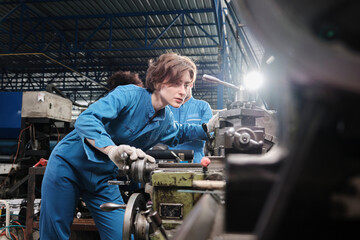 Professional young White female industry engineer worker works in safety uniform with metalwork...