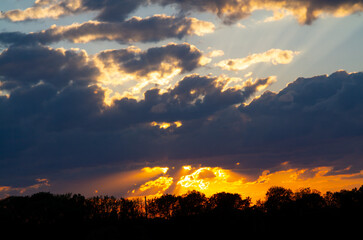 Windy sunset with black clouds. Natural real background with the last rays of the sun cloud....