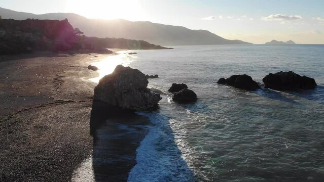 Drone Aerial View Of The Sea Beach With Quiet Waves And Rocks In The Morning Sunlight