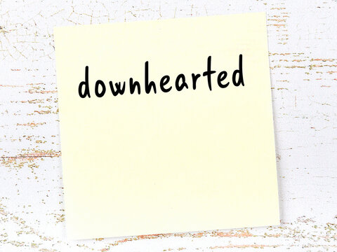 Yellow sticky note on wooden wall with handwritten word blasphemous
