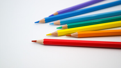 Many different colored pencils on white background