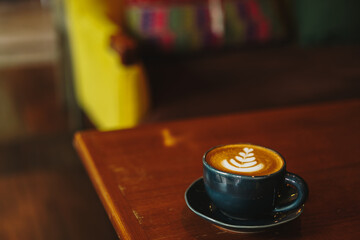 cup of latte art coffee on wooden background