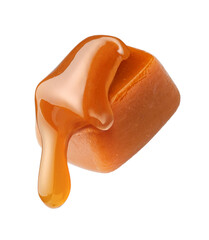 Caramel sauce flowing on caramel cube isolated on white background. Caramel candy with liquid...