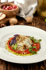 Hot appetizer - baked eggplant with cheese and tomatoes. Stuffed eggplants with mozzarella cheese and tomato sauce in rustic style. Eggplant and cheese appetizer on white plate in italian style.