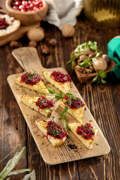 Hot appetizer for wine - grilled halloumi cheese with jam. Cheese appetizer baked halloumi on wooden background on rustic style. Adyghe cheese with berries dip on wooden table.