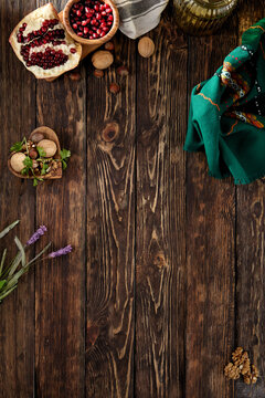 Rustic wooden background  with pomegranate, textile and nuts. Armenian background with walnuts and fruits. Georgian wooden banner. Azerbaijan food background.