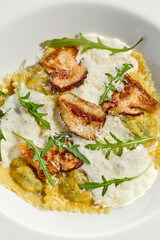 Mushroom ravioli and cheese sauce isolated on white background. Italian dish - ravioli with porcini and creamy espuma on white plate. Restaurant dishes with wild mushroom.