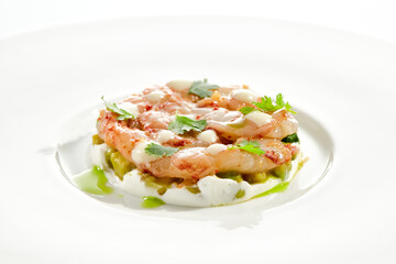 Restaurant dish - shrimp tartare with avocado, cream cheese, sweet chilli sauce on white plate. Ceviche with marinated prawn, avocado and spicy vegetables. Prawn tartare isolated on white background.