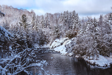View on Devil's river waterfall (Chute de la rivière au Diable) under the snow during winter, located near Mont Tremblant in Quebec (Canada)