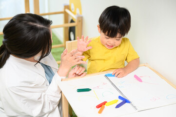 幼児と絵を描くママさん　ハイタッチ
