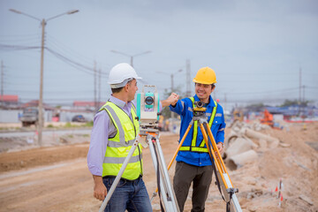 Surveyor engineer wearing safety uniform and helmet with equipment theodolite to measurement...