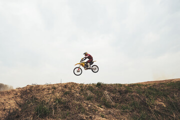 Jumping in air motorcyclist on  motocross motorcycle at the training ground