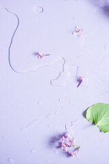 Fototapeta na wymiar Lilac flat lay, pastel colors, spilled water, florist workplace