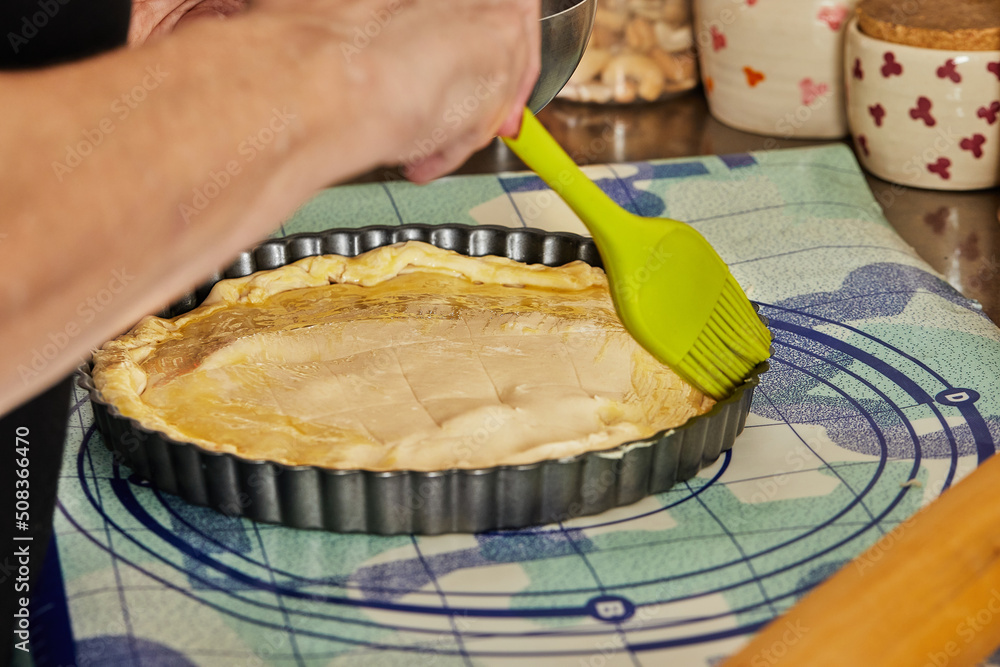 Canvas Prints Chef uses special brush to brush the pie dough with egg before baking in the oven