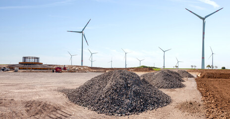 Construction site and agriculture field. Preparation of a wind turbines with concrete and steel....