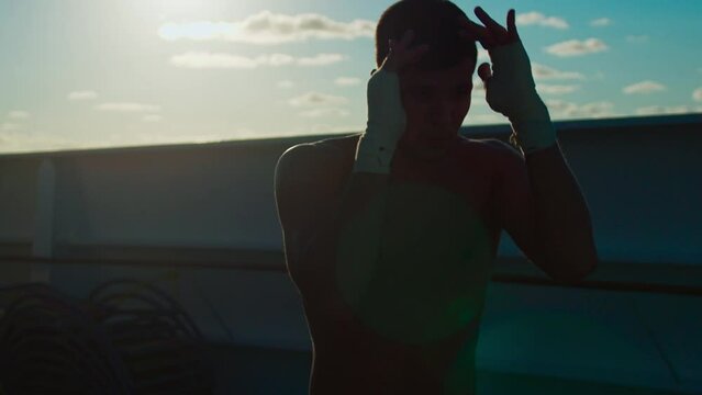 Silhouette of young man practice shadow boxing outdoors onboard cruise ship