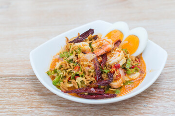 Thai wing bean salad with fresh coconut milk shrimp served with boiled eggs is a delicious Thai food style while put on a wooden table.