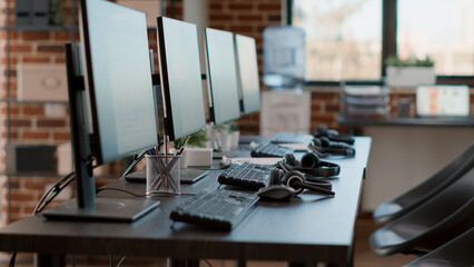 Empty customer service workstation to help telemarketing clients, modern call center technology for...
