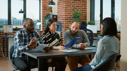 Diverse group of workers attending job interview meeting with applicant, talking about work...