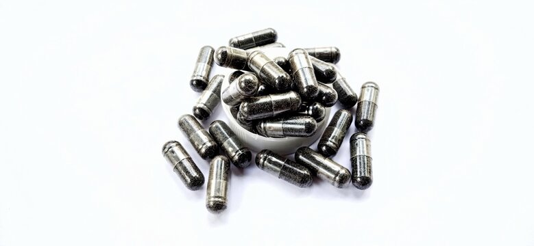 Herbal medicine black cumin capsules with negative space isolated on the gray white studio background. Nigella sativa. Suitable for promotion of health industry and company.