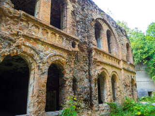 Ancient brick ruins of old fortification fort outpost. Monument of military history in Tarakaniv, Ukraine. Dubno fortress, ruined war fortification. Abandoned fortress outside, ruined wooded citadel.