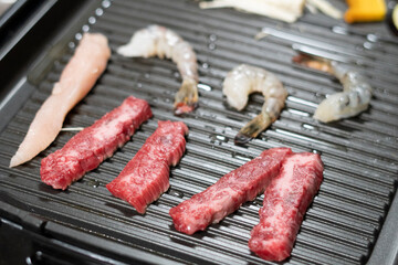 鉄板で肉や海老を焼く　イメージ