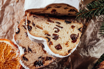 Christmas stollen on wooden background. Traditional christmas german dessert cut into pieces. Cake with nuts, raisins with marzipan and dried fruit on cutting board. baking for xmas