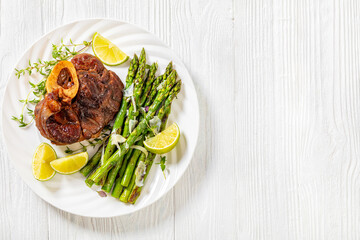 braised osso buco with grilled asparagus, top view
