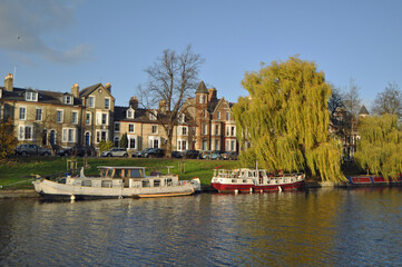 A picturesque view of boats on the river Cam in Cambridge in the Autumn with trees U.k.