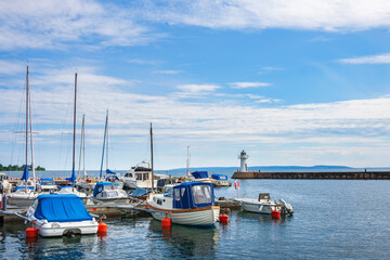 Boats in a marina with a lighthouse