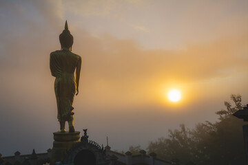 Fototapeta premium Golden Buddha statue in the morning at Wat Phra That Khao Noi, or Phrathat Khao Noi temple, is the top attraction with a fantastic view of Nan province, Thailand