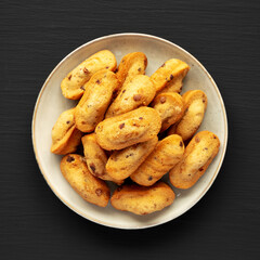 Homemade Chocolate Chips Madeleines on a Plate on a black surface, top view. Flat lay, overhead, from above.
